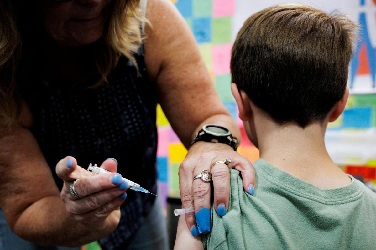 A child receives a dose of the Moderna coronavirus disease (COVID-19) vaccine at Skippack Pharmacy in Schwenksville, Pennsylvania, U.S. September 11, 2025. REUTERS/Hannah Beier